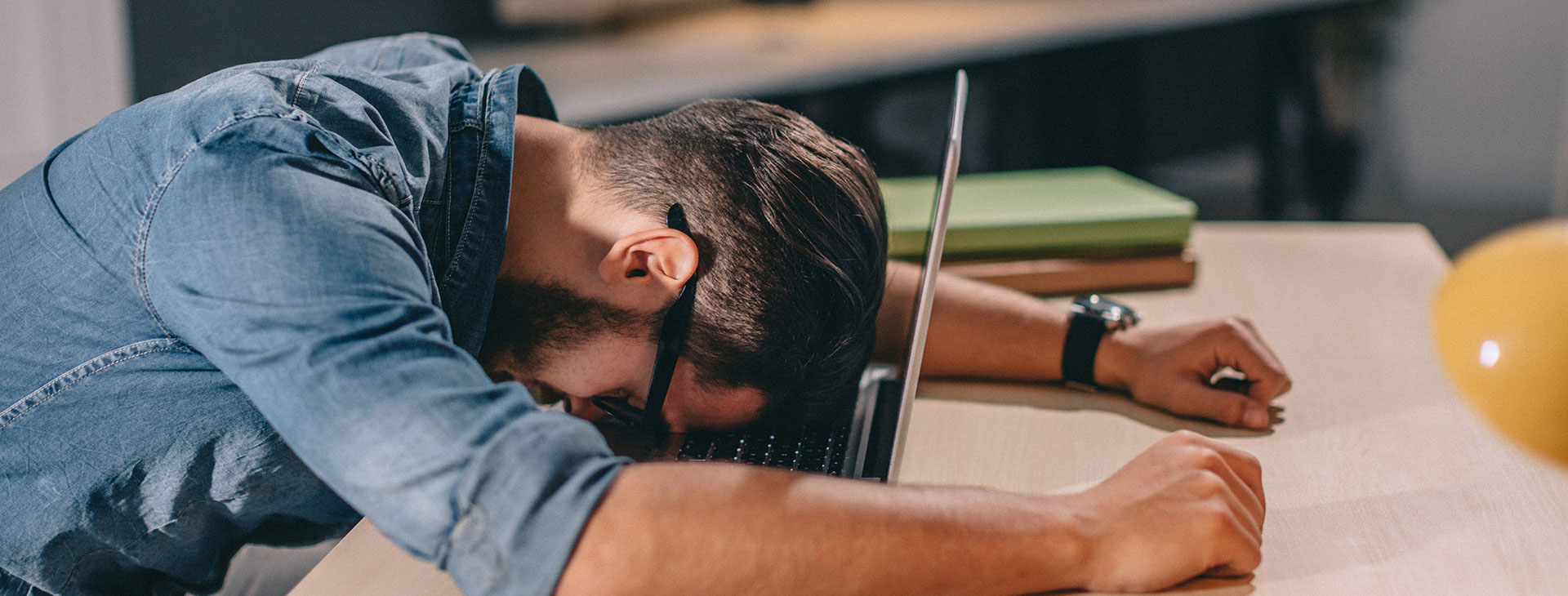 Man slumped over laptop as job sucks